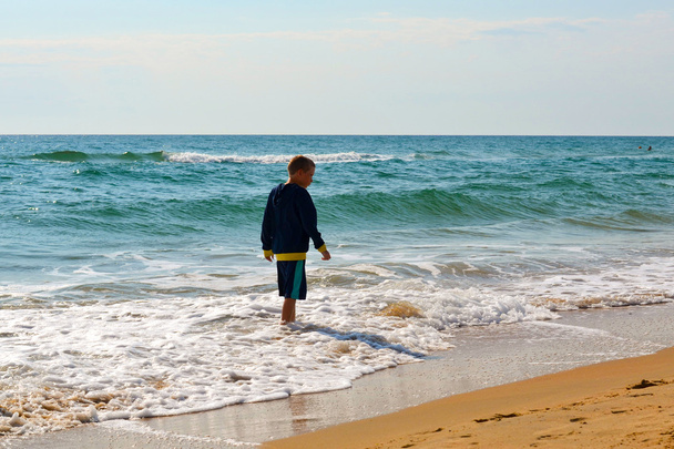 The teenage boy goes on the seashore. - Photo, Image