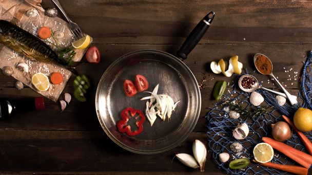 Cooking background. Smoked fish with spices and lemon on a wooden background. Maritime style, a blue fishing net and shells, top view. - Fotó, kép