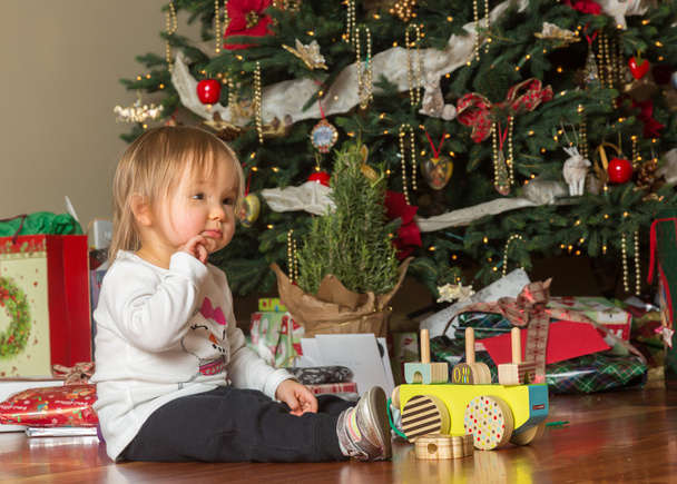 Μικρά καυκάσιος μωρό κορίτσι άνοιγμα παρουσιάζει Χριστούγεννα - Φωτογραφία, εικόνα