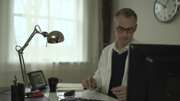 A medical doctor at his office desk - Záběry, video