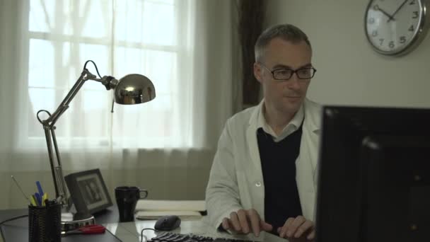 A medical doctor at his office desk - Felvétel, videó
