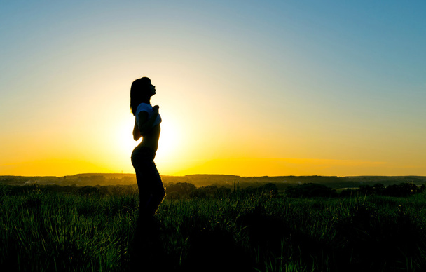 Silhouette jeune femme devant un beau coucher de soleil
 - Photo, image
