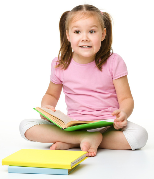 Χαριτωμένο κοριτσάκι διαβάζει ένα βιβλίο - Φωτογραφία, εικόνα