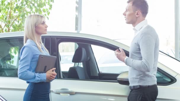 Customer and saleswoman discussing a vehicle. - Felvétel, videó