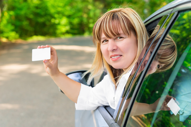 Naiskuljettaja näyttää tyhjää korttia
 - Valokuva, kuva