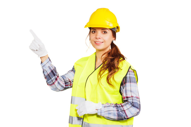 Young woman in construction helmet and yellow vest - Zdjęcie, obraz