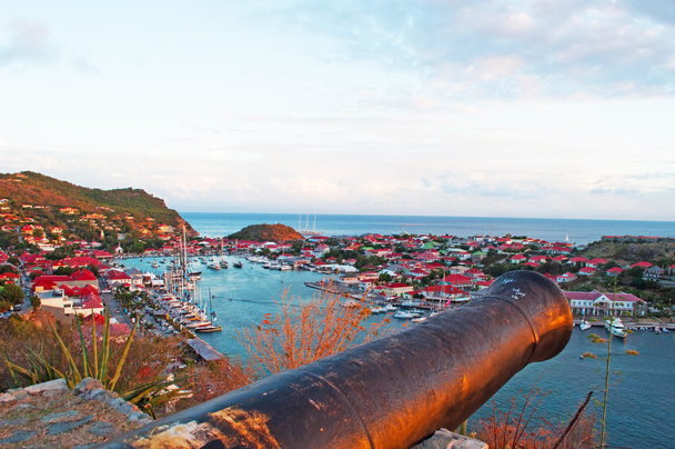 Saint Barthelemy (St Barth, St. Barths ou St. Barts), Mar do Caribe: vista árida do horizonte e do porto de Gustavia ao pôr do sol ao longo da caminhada para Fort Gustav com seu antigo canhão
 - Foto, Imagem