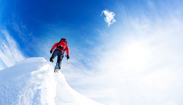 Bergsteiger erreichen den Gipfel eines verschneiten Gipfels. Konzepte: Entschlossenheit, Mut, Anstrengung, Selbstverwirklichung. - Foto, Bild