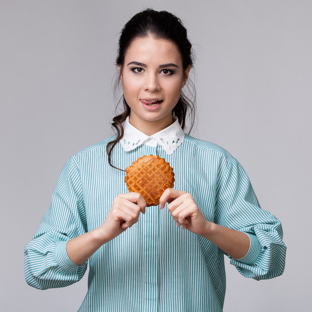 Giovane donna bruna con un bisquit
 - Foto, immagini