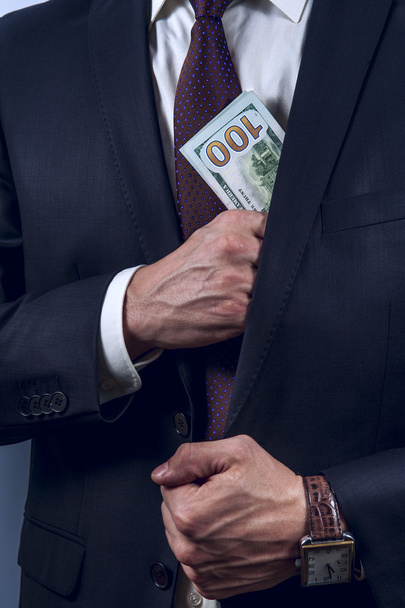 Man removes US dollars in his suit pocket - Φωτογραφία, εικόνα