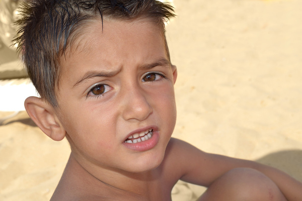 Stroppy παιδί στην παραλία λέει κάτι - Φωτογραφία, εικόνα