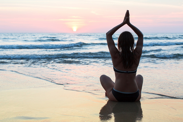 Frau praktiziert Yoga am Strand - Foto, Bild
