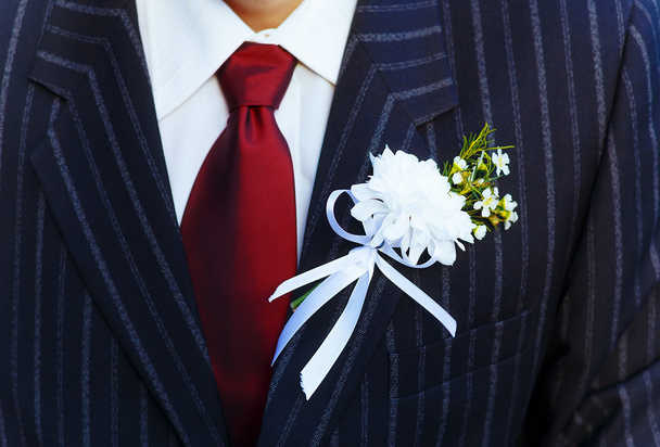 primer plano negro chaqueta novio en su boda día con una corbata roja y solapa ojal
. - Foto, imagen
