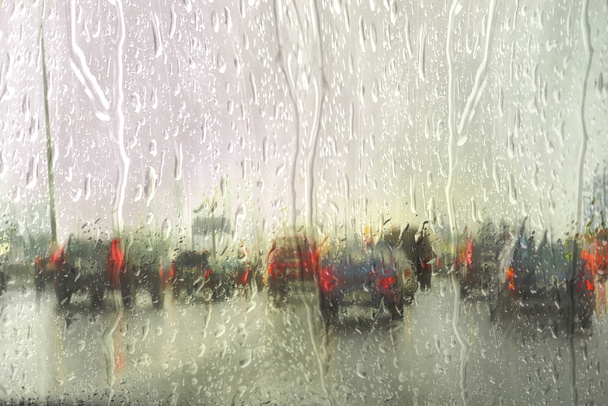 Vue sur la route à travers la fenêtre de la voiture avec gouttes de pluie, Conduite sous la pluie. - Photo, image