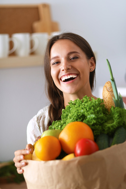 Giovane donna che tiene la spesa con verdure - Foto, immagini