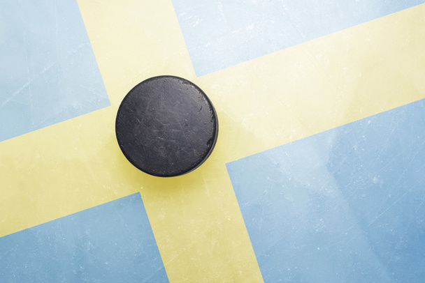 vanha jääkiekko kiekko on jäällä Ruotsin lippu
 - Valokuva, kuva