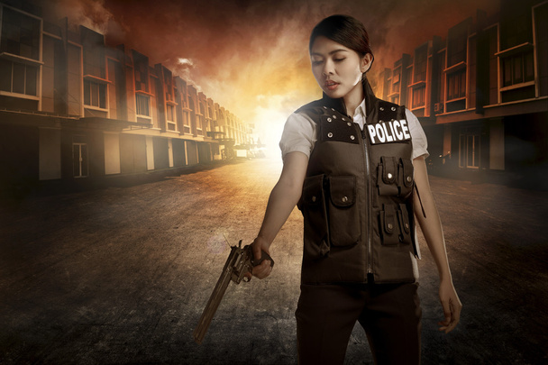 Beautiful police woman holding gun - Фото, изображение