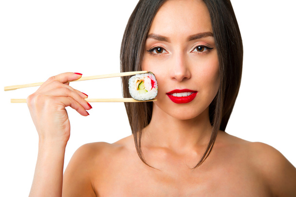 Mujer joven sosteniendo sushi con palillos, aislado en blanco
 - Foto, Imagen