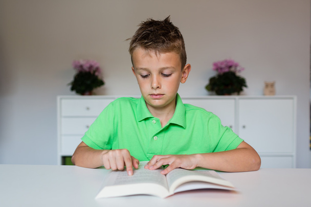 молодий хлопчик читає книгу
 - Фото, зображення