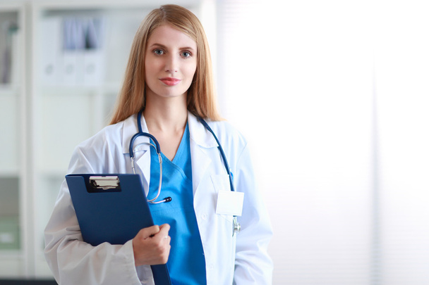 Portrait of woman doctor with folder at hospital corridor - Photo, Image