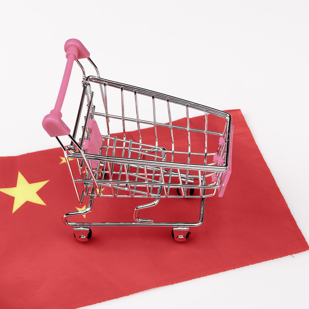 pink shopping cart on china flag - Foto, afbeelding