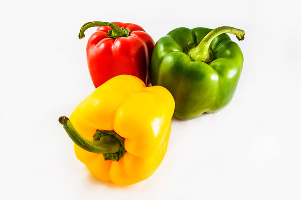 drei süße rote, gelbe, grüne Paprika isoliert auf weißem Hintergrund. - Foto, Bild
