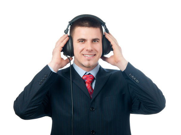 χαμογελώντας όμορφος επιχειρηματίας ακούγοντας μουσική μέσω των ακουστικών που απομονώνονται σε λευκό - Φωτογραφία, εικόνα