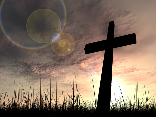 Concept conceptuele zwarte kruis of religie symbool silhouet in gras over een zonsondergang of zonsopgang hemel met zonlicht wolken achtergrond - Foto, afbeelding