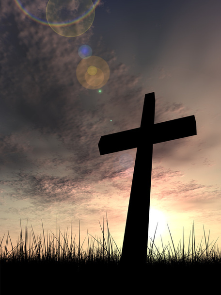 Concept conceptual black cross or religion symbol silhouette in grass over a sunset or sunrise sky with sunlight clouds background - Photo, Image