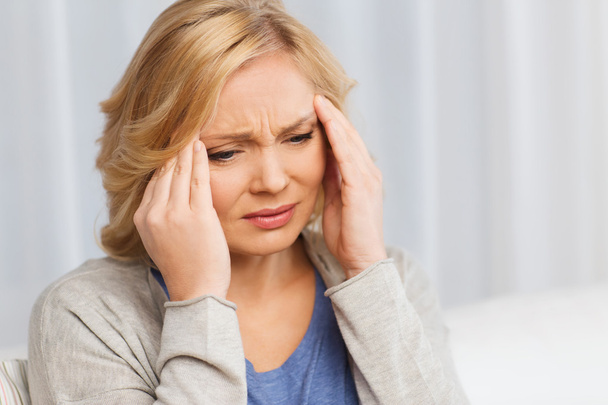unhappy woman suffering from headache at home - Foto, afbeelding