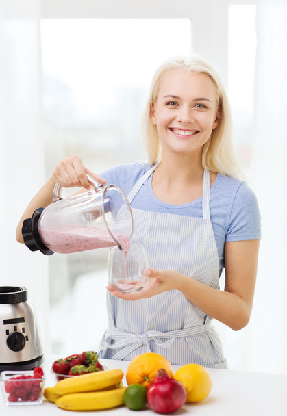 smiling woman with blender preparing shake at home - Fotó, kép