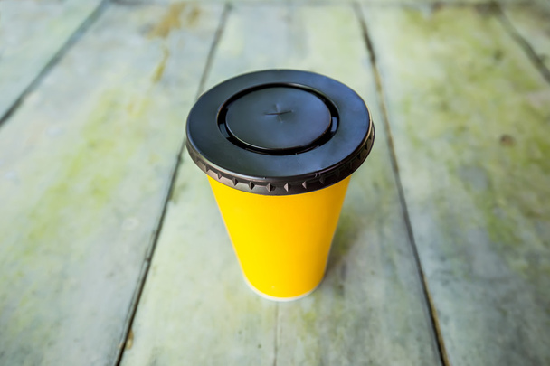 tasse jetable en papier jaune sur plaque de bois
 - Photo, image