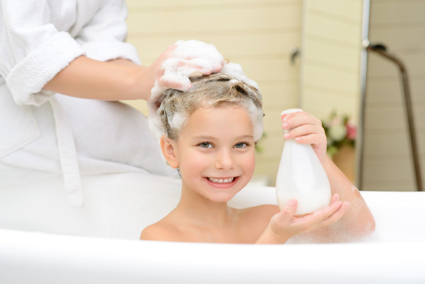 Cute little girl washing her hair - 写真・画像