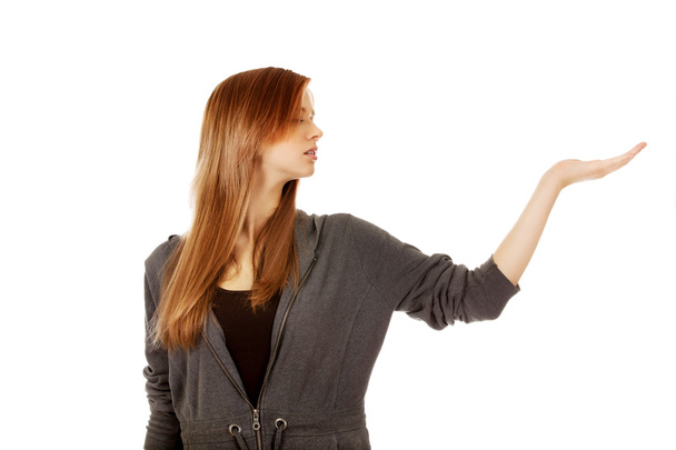 Teenage woman presenting something on open palm - Photo, Image