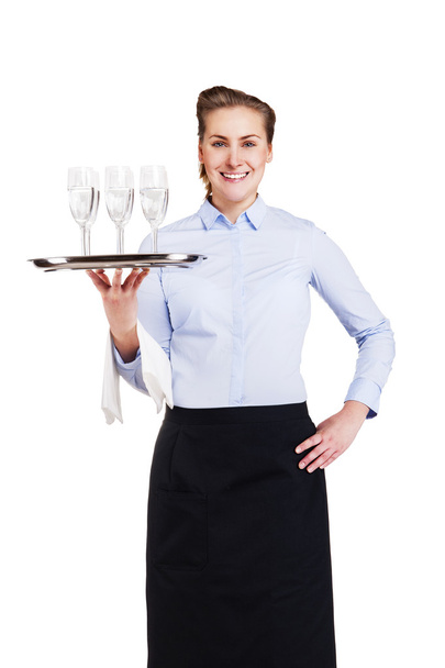 Woman in waiter uniform holding tray with glasses, smiling, isol - Foto, Imagen