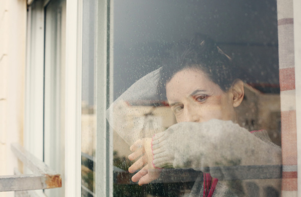 Femme regardant par la fenêtre
 - Photo, image