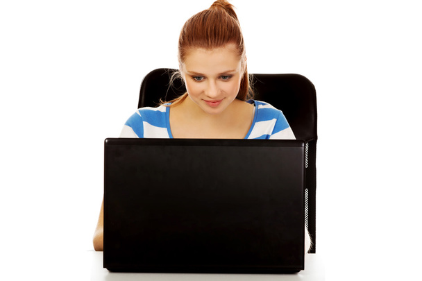 Teenage smiling woman using laptop - Valokuva, kuva