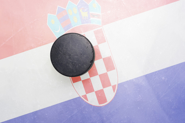 viejo disco de hockey está en el hielo con bandera de croacia
 - Foto, imagen