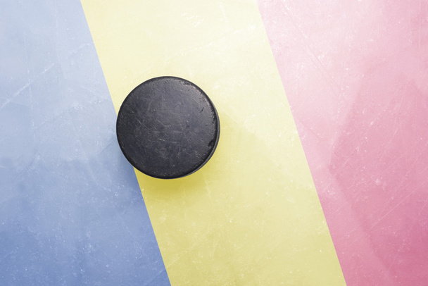 vecchio disco da hockey è sul ghiaccio con la bandiera della Romania
 - Foto, immagini