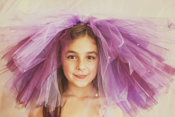 Egy vicces kalap lila ruhába öltözött lány - Fotó, kép