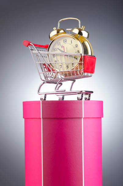 Ostaminen aika käsite kellon ja ostoskorin - Valokuva, kuva