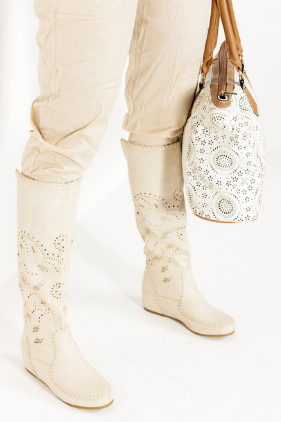 donna in piedi che indossa stivali estivi in possesso di una borsa
 - Foto, immagini