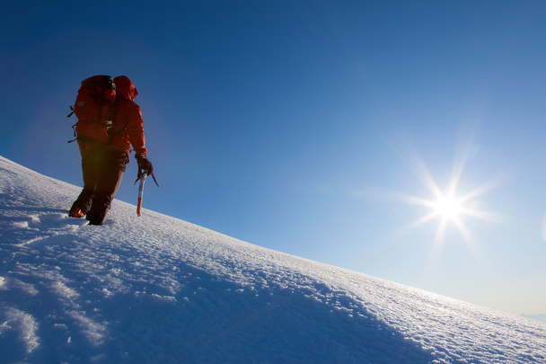 Climber walks on a glacier. Winter season, clear sky.  - Photo, Image