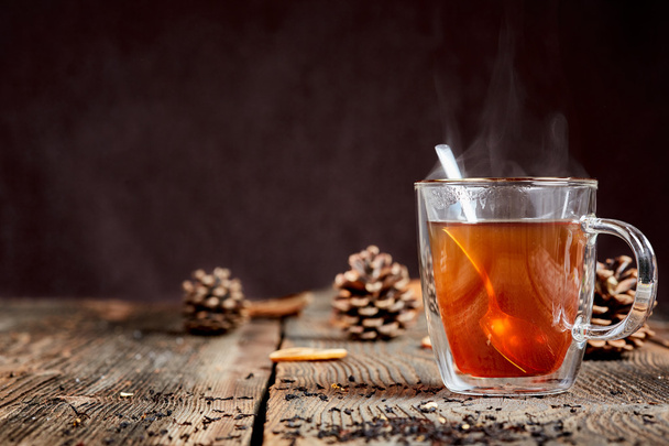 Chá e mel fumegantes em uma mesa de madeira com cones de pinho
 - Foto, Imagem