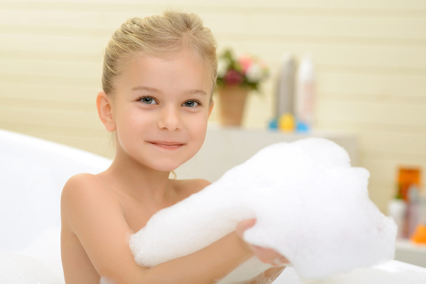 Pleasant little girl playing in bath tube - Photo, image