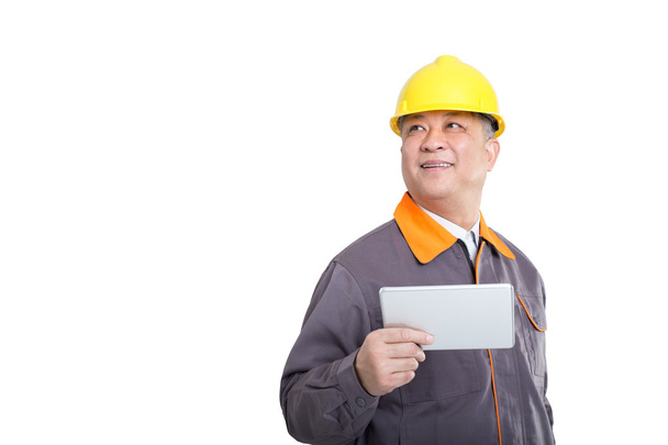 Ingenieur im gelben Bollenhut mit Tablet  - Foto, Bild