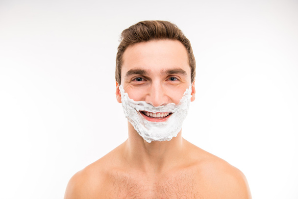 Handsome cheerful man with shaving foam on his face  - 写真・画像