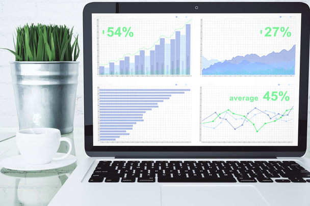 Gráfico de negócios no desktop laptop com xícara de café e gr verde
 - Foto, Imagem