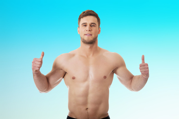 Sexy muscular man showing thumbs up. - Photo, image