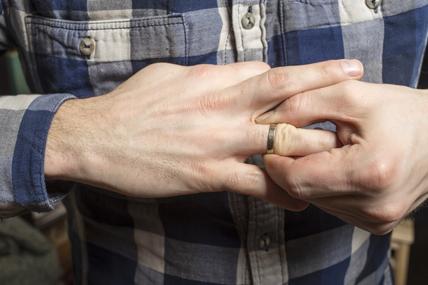 Αφαιρέστε το γαμήλιο δαχτυλίδι από το δάχτυλό του - Φωτογραφία, εικόνα
